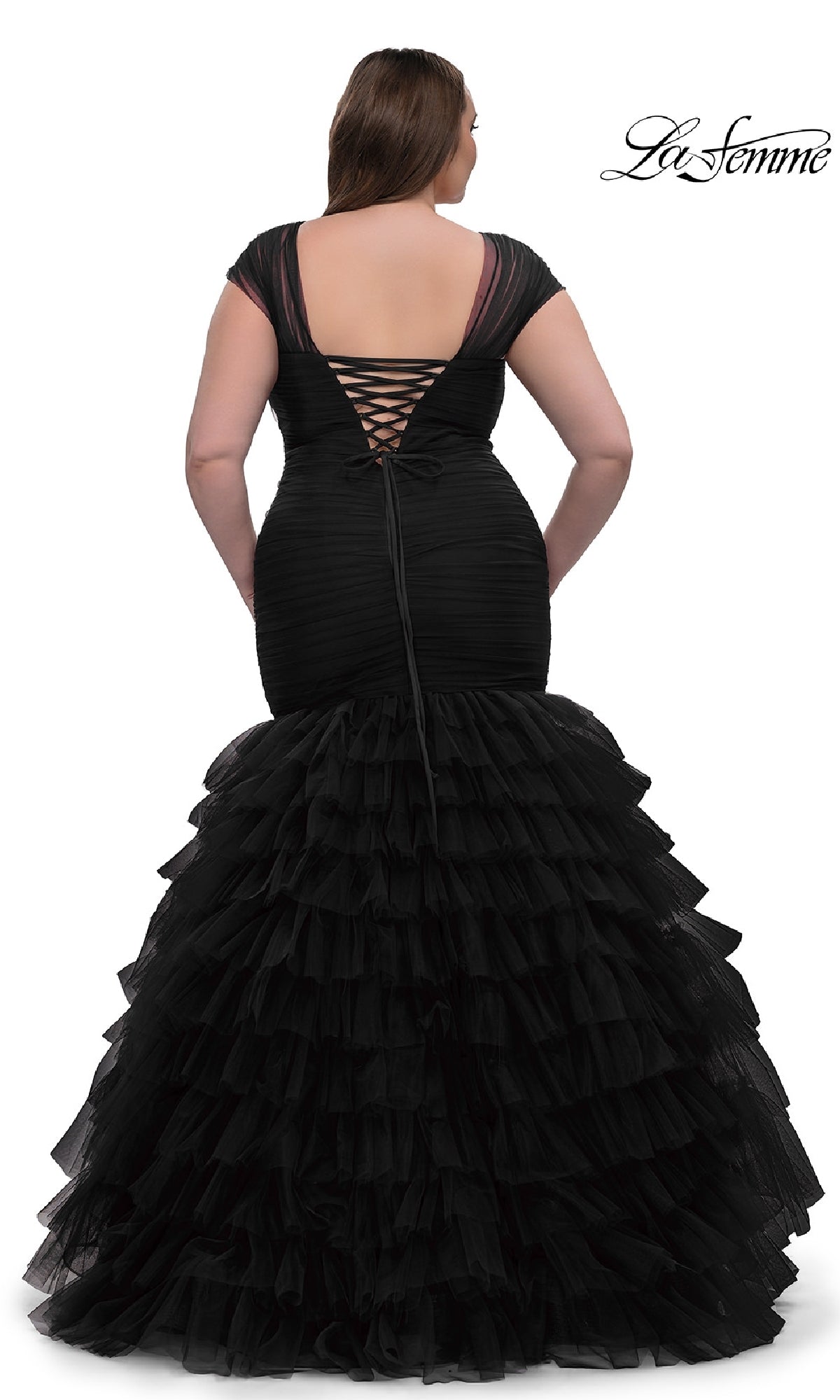 Woman wearing Plus-Size Long Mermaid Prom Dress La Femme 32389, featuring a black, floor-length ruffled tulle skirt and lace-up open back, stands facing away.